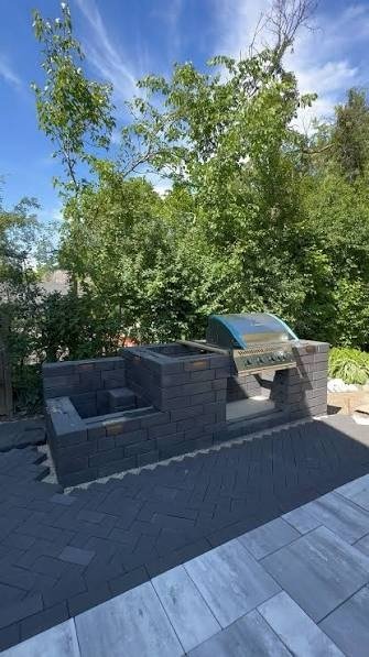Charcoal brick grill island on a herringbone patio