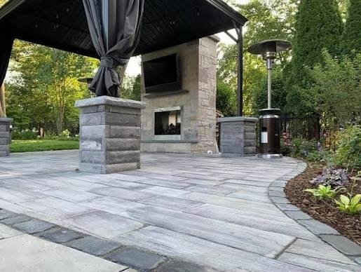 Paver patio with a pavilion, stone fireplace and pillars